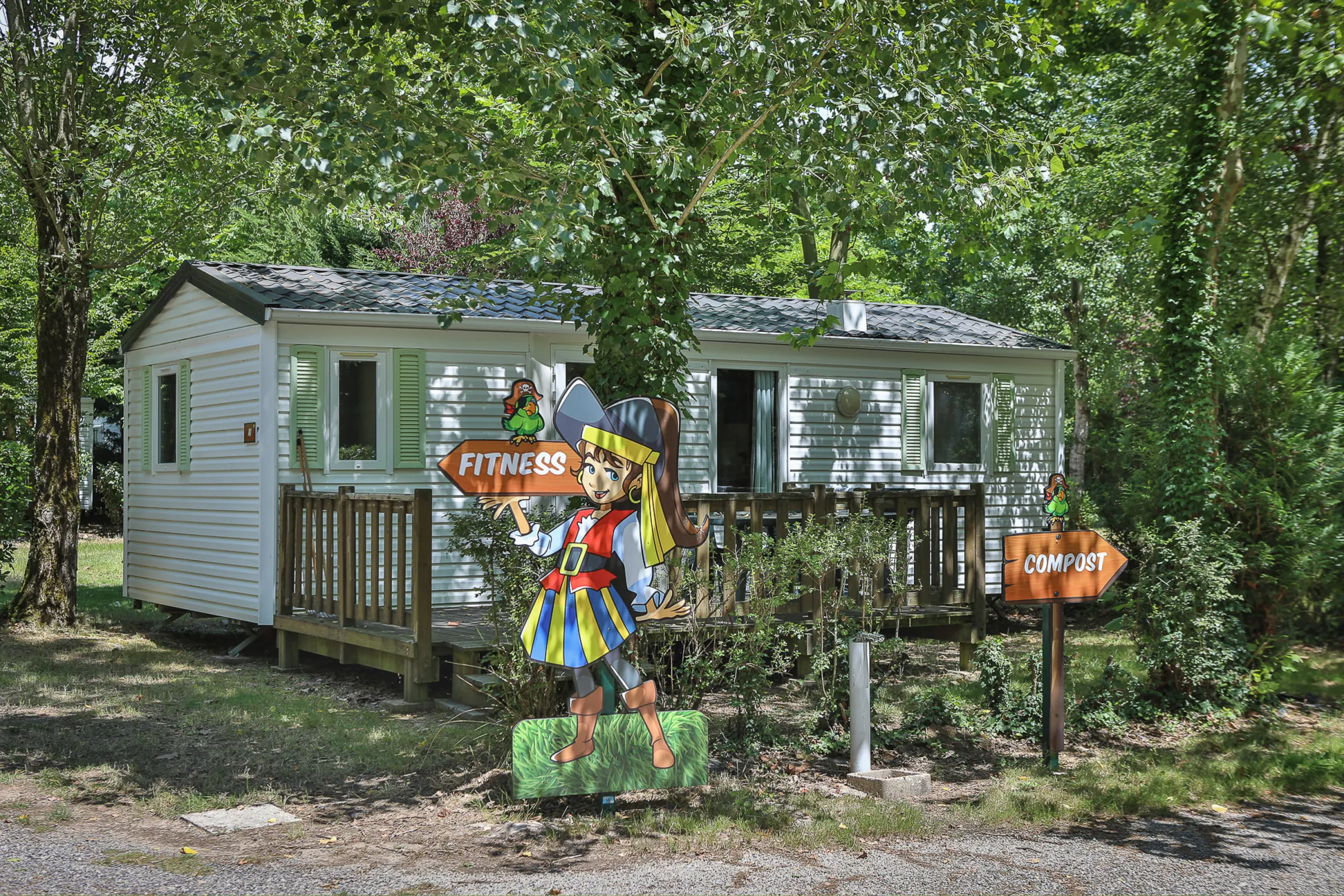 Mobil-home et sa terrasse sous les arbres