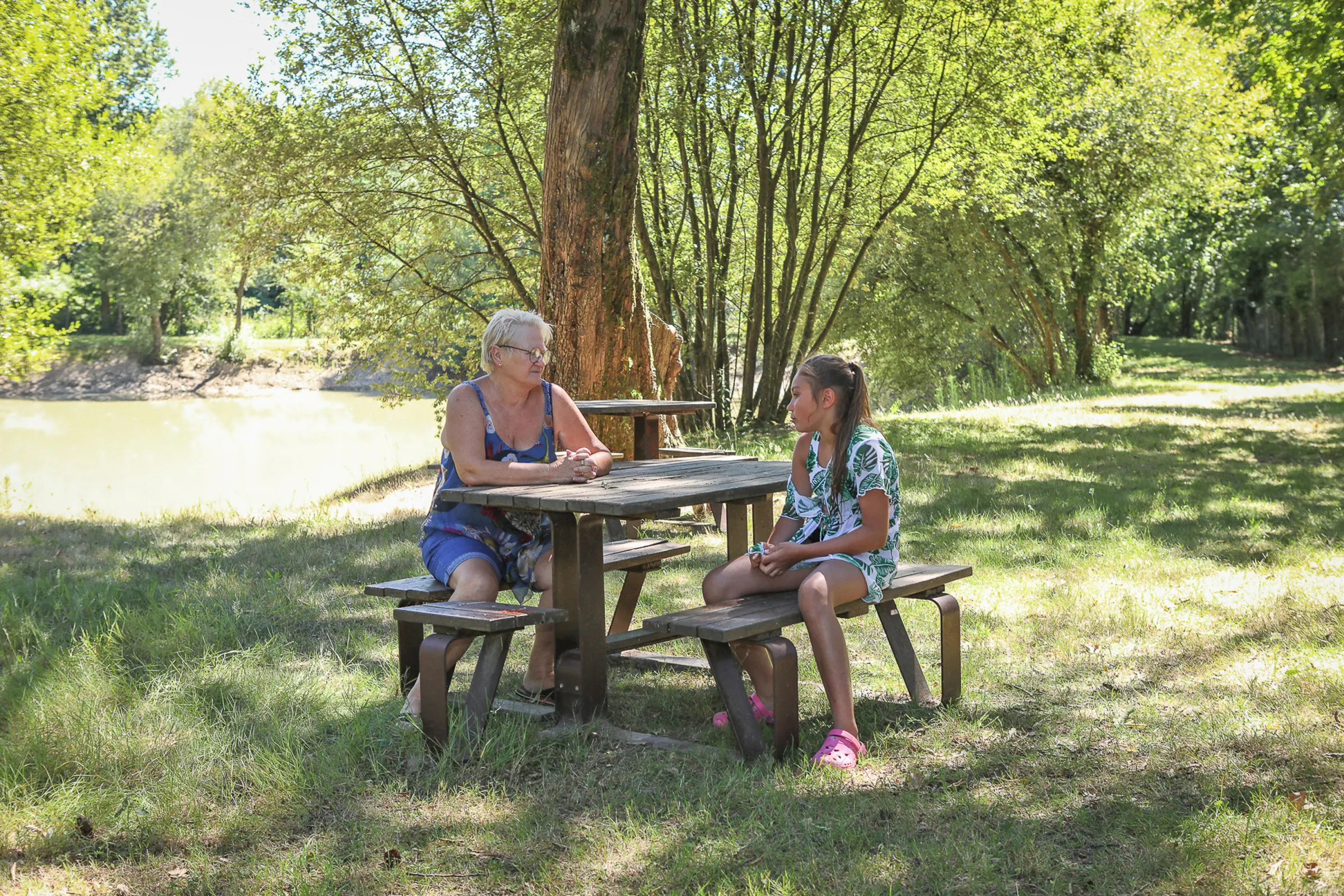 Pique-nique à l’ombre au bord de l’étang du camping
